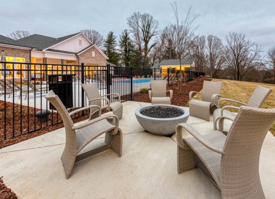 a patio with chairs and a fire pit in front of a pool at Retreat at Arden Farms, North Carolina, 28704