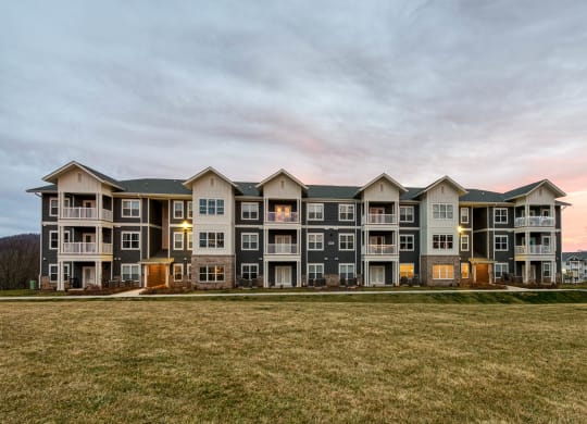 an exterior view of an apartment building on a grass field at Retreat at Arden Farms, Arden, NC