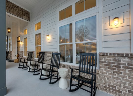 a row of chairs on the porch of a building at Retreat at Arden Farms, Arden, NC 28704