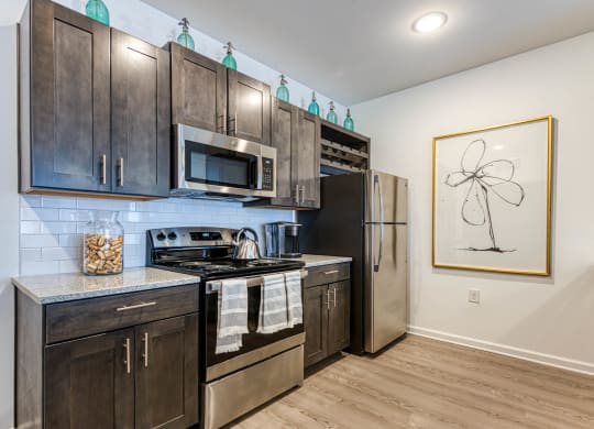 a kitchen with stainless steel appliances and wooden cabinets at Retreat at Arden Farms, Arden, NC