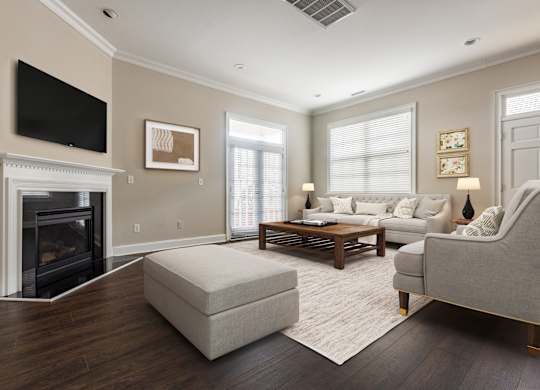 A living room with a fireplace and a flat screen TV mounted on the wall.