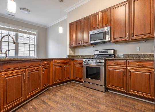 A kitchen with wooden cabinets and a stainless steel oven.