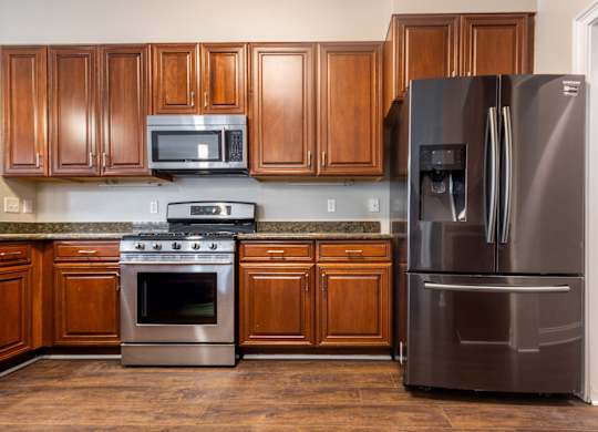 A kitchen with a stainless steel refrigerator, oven, and microwave.
