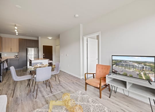 a living room with a tv and a dining room in the background at Rivergate, Woodbridge, Virginia