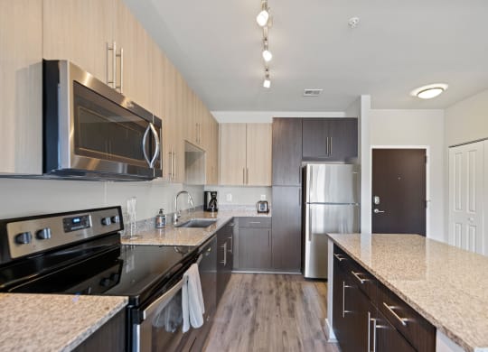 a kitchen with granite countertops and stainless steel appliances at Rivergate, Woodbridge