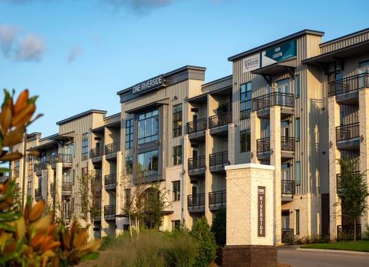 a row of apartment buildings with trees in the foreground  at One Riverside Apartments, Tennessee
