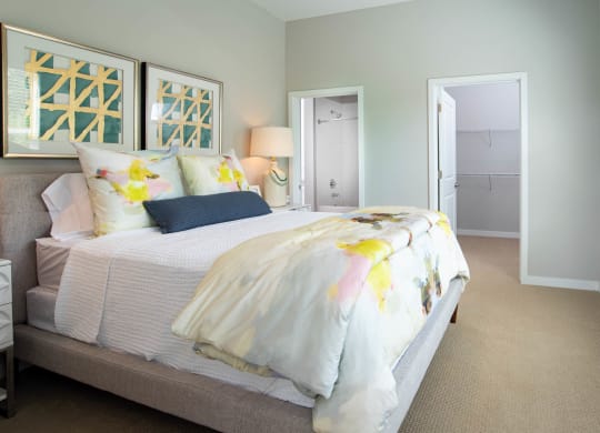 a bedroom with a bed and a door to a closet at One Riverside Apartments, Chattanooga