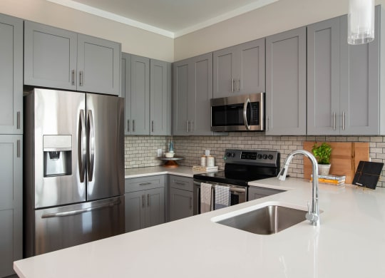 a kitchen with stainless steel appliances and white counter tops at One Riverside Apartments, Chattanooga, 37403