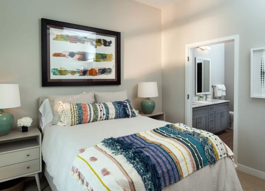 a bedroom with a large bed and a mirror at One Riverside Apartments, Chattanooga, 37403