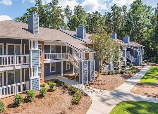 A large two-story house with a balcony and a covered patio. at The Colony at South Park, Aiken