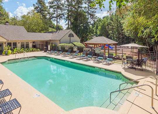 A large outdoor swimming pool surrounded by lounge chairs at Woodwinds, Aiken, 29803