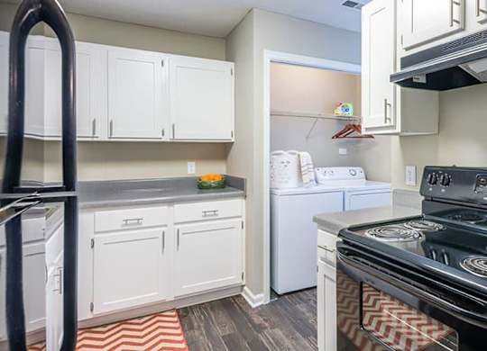 A kitchen with a black stove top oven and white cabinets. at Woodwinds, Aiken, 29803