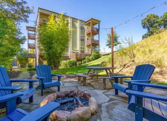 fire pit and chairs on a patio with a building in the background at Skyloft, Asheville, NC 28803