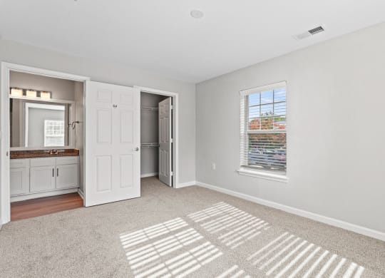 a renovated living room with a window and a door to a bathroom at SomerHill Farms Apartments, Gainesville Virginia