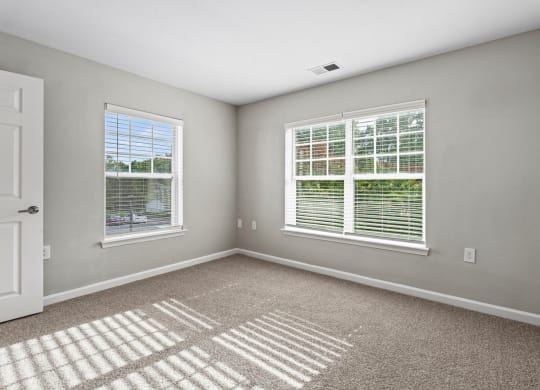 an empty room with two windows and a door at SomerHill Farms Apartments, Gainesville, 20155