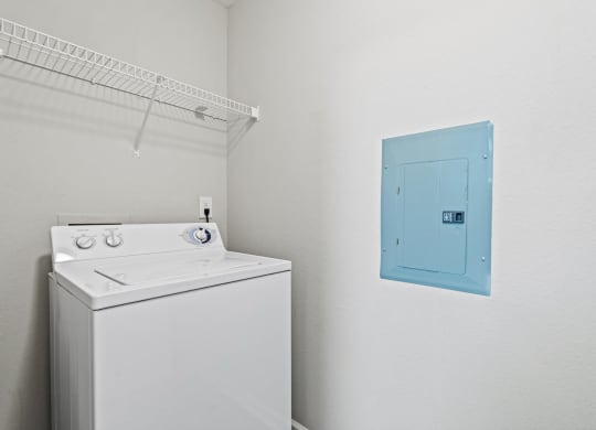 a white washer and dryer in a room with a blue door at SomerHill Farms Apartments, Gainesville, VA 20155