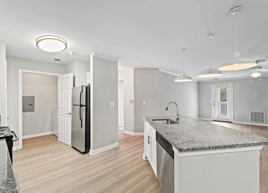 a renovated kitchen with a granite counter top and stainless steel refrigerator at SomerHill Farms Apartments, Gainesville, VA 20155