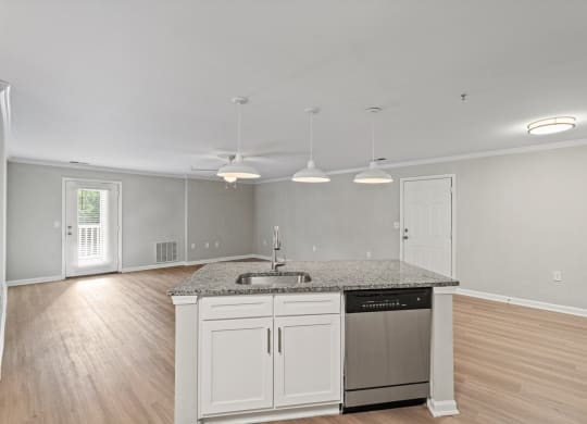 an empty kitchen with white cabinets and a sink and a counter top at SomerHill Farms Apartments, Virginia