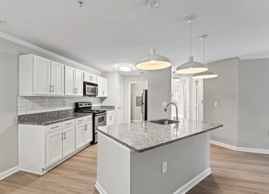 a kitchen with white cabinets and a marble counter top at SomerHill Farms Apartments, Gainesville, VA 20155