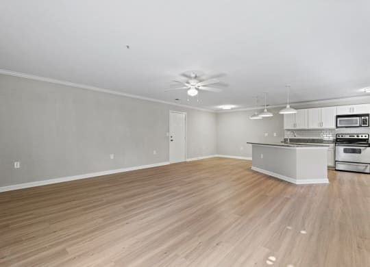 the living room and kitchen of a new home with wood flooring at SomerHill Farms Apartments, Gainesville