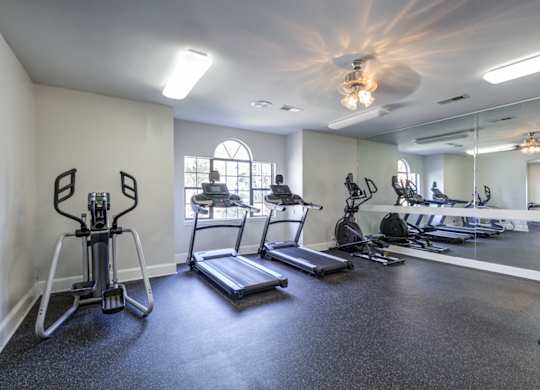 A spacious gym with treadmills, exercise bikes, and other equipment at Southland Station Apartments in Warner Robins, Georgia, 31088
