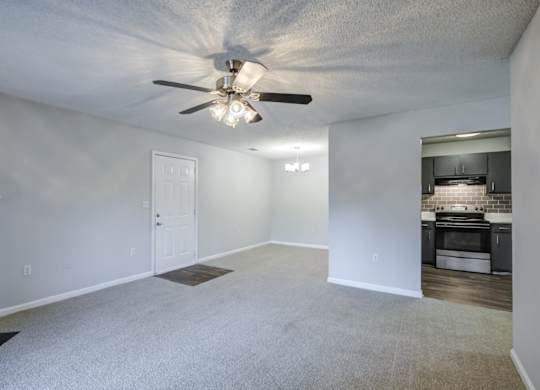 A spacious room with a ceiling fan and a fireplace at Southland Station Apartments in Warner Robins, 31088