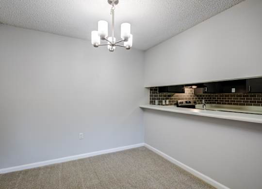 A room with a chandelier and a counter with a backsplash at Southland Station Apartments in Warner Robins, Georgia