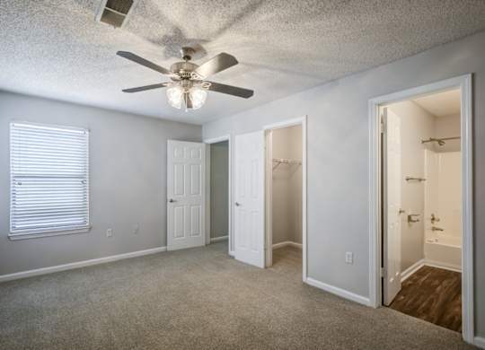 A room with a ceiling fan and a carpeted floor at Southland Station Apartments in Warner Robins, Georgia, 31088