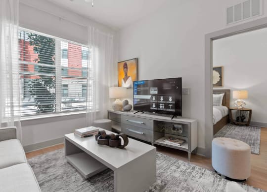 a living room with a large window and a white coffee table at Tapestry West, Virginia