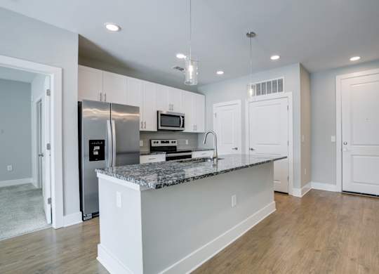 A kitchen with a granite countertop and stainless steel appliances.