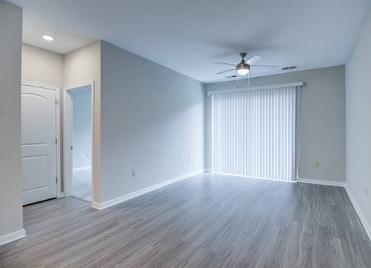 A room with a ceiling fan and lighting fixture.
