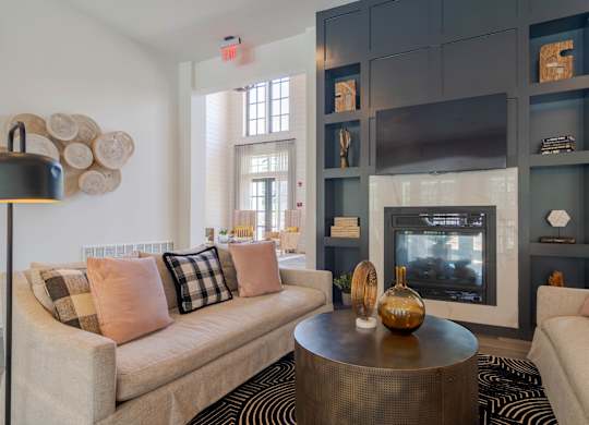A living room with a beige couch, a coffee table, and a fireplace.