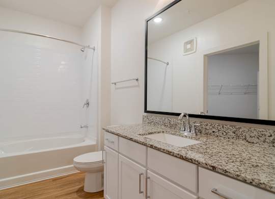 A bathroom with a marble countertop and a white toilet.