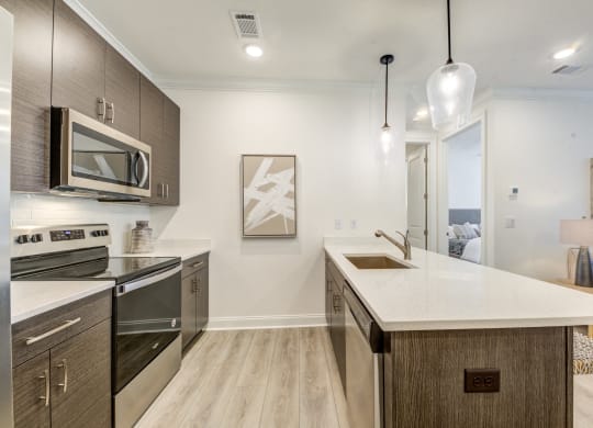 a kitchen with an island and a stove and a microwave at Residences at 393 North Apartments, Santa Rosa Beach