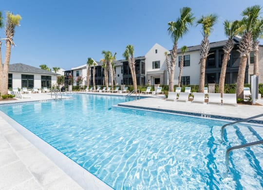 a swimming pool with palm trees and apartments in the background at Residences at 393 North Apartments, Santa Rosa Beach, Florida