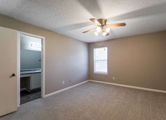 A room with a ceiling fan and a window.