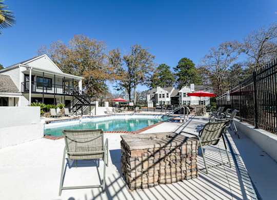 A pool area with a chair and a fence.