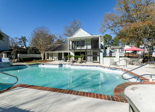 A swimming pool in front of a house.
