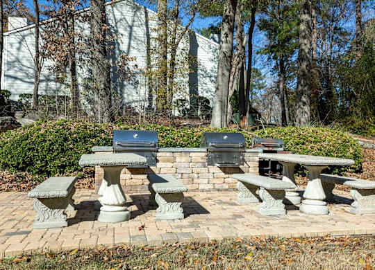 A set of four stone picnic tables are set in a brick circle.