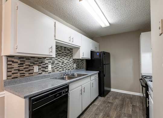 A kitchen with black appliances and white cabinets.