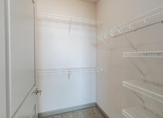A white refrigerator with empty shelves and a door open.