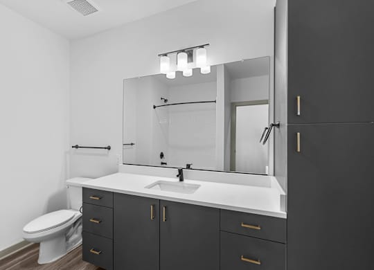 A bathroom with a white sink and a white toilet.