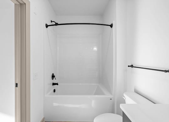 A white bathroom with a tub, toilet, and sink.