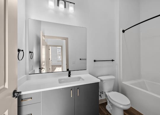 A white bathroom with a sink, toilet, and bathtub.