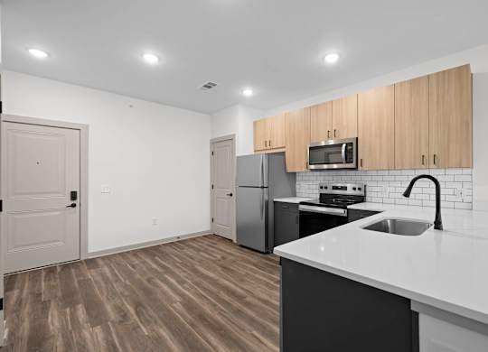 A kitchen with a white counter top and wooden cabinets.