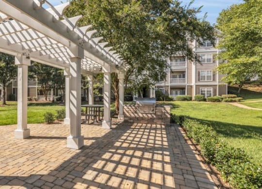 a pergola on a brick sidewalk in front of an apartment building at Marina Point, Chattanooga, TN