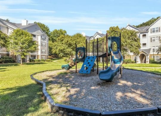 a playground in a park with houses in the background at Marina Point, Tennessee