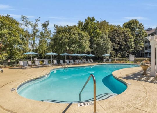 a swimming pool with umbrellas next to a building at Marina Point, Chattanooga, TN 37415