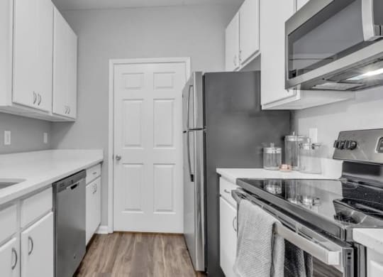 a kitchen with stainless steel appliances and white cabinets at Marina Point, Tennessee