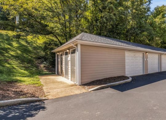 a white and tan garage with a driveway and trees at Marina Point, Chattanooga